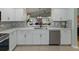 Modern kitchen featuring white cabinets, mosaic backsplash, stainless steel appliances, and a view to the backyard at 1338 Winding Willow Dr, Trinity, FL 34655