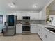 Bright kitchen with stainless steel appliances, white cabinets, and tile flooring at 1338 Winding Willow Dr, Trinity, FL 34655