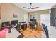 Well-lit office offers multiple desk spaces, ideal for a productive work environment with ceiling fan and wood flooring at 1338 Winding Willow Dr, Trinity, FL 34655