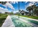 Outdoor shuffleboard courts with clear markings, surrounded by palm trees, and a view of the clubhouse at 1338 Winding Willow Dr, Trinity, FL 34655