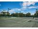 Well-maintained tennis court with green surface, net, and lights, perfect for daytime or evening play at 1338 Winding Willow Dr, Trinity, FL 34655