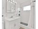 Clean bathroom with white vanity, shower with white tile and a shower curtain at 13795 Antigua Dr, Seminole, FL 33776