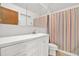 Clean bathroom featuring a white vanity, mirror, and striped shower curtain at 13795 Antigua Dr, Seminole, FL 33776