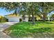 Charming single-story home with a lush green lawn, mature trees, and a two-car garage at 13795 Antigua Dr, Seminole, FL 33776