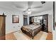 Cozy bedroom with black and gold bedding, mirrored dresser, ceiling fan, and carpeted floors at 1414 75Th Nw St, Bradenton, FL 34209