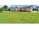Exterior view of a charming single-story home featuring a red tile roof and a large front yard with lush grass at 1414 75Th Nw St, Bradenton, FL 34209