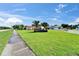View of a well-manicured front lawn and sidewalk leading to a charming single-story home with a red tile roof at 1414 75Th Nw St, Bradenton, FL 34209