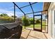 View of the backyard from the screened-in lanai with grill at 1414 75Th Nw St, Bradenton, FL 34209