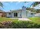 Rear exterior of the house with a brick firepit, sliding glass doors, and a well-kept lawn at 1420 Temple St, Clearwater, FL 33756