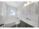 Bright bathroom features a tub with shower and gray vanity with white sink and cabinet at 1420 Temple St, Clearwater, FL 33756