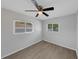 Bedroom offers wood-look floors, ceiling fan, two windows, and neutral gray walls at 1420 Temple St, Clearwater, FL 33756