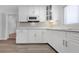 Bright kitchen features white cabinets, subway tile backsplash, stainless microwave, and modern hardware at 1420 Temple St, Clearwater, FL 33756