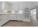This kitchen features white cabinets, stainless oven appliances, subway tile backsplash, and wood-look flooring at 1420 Temple St, Clearwater, FL 33756