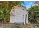 White wooden shed surrounded by greenery and flowers at 1420 Temple St, Clearwater, FL 33756
