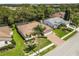 Aerial view of home with a paver driveway, manicured landscaping, and mature trees at 14228 Teasdale Ave, Hudson, FL 34667