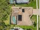 Aerial view of house featuring solar panels, screened in pool, and mature landscaping at 14228 Teasdale Ave, Hudson, FL 34667