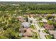 An aerial view of a residential neighborhood with mature trees, sidewalks, and a community green space at 14228 Teasdale Ave, Hudson, FL 34667