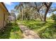 Lush backyard with mature trees and a brick pathway, offering a serene outdoor escape at 14228 Teasdale Ave, Hudson, FL 34667