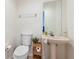 Small half bathroom with pedestal sink, toilet, and mirrored wall at 14228 Teasdale Ave, Hudson, FL 34667