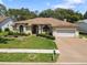 Charming home with well-manicured lawn, arched windows, and a two-car garage at 14228 Teasdale Ave, Hudson, FL 34667
