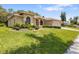 Charming single-story home with lush green lawn, complemented by manicured shrubs and an attached garage at 14228 Teasdale Ave, Hudson, FL 34667