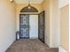 Inviting front porch with wrought iron security door, lantern, and brick flooring at 14228 Teasdale Ave, Hudson, FL 34667