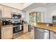 Modern kitchen featuring stainless steel appliances and access to screened pool at 14228 Teasdale Ave, Hudson, FL 34667