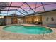 Enclosed pool with brick patio, featuring comfortable seating, perfect for relaxing and entertaining in style at 14228 Teasdale Ave, Hudson, FL 34667