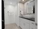 Stylish bathroom featuring white marble wall tiles, white cabinets with black countertop and a vessel sink at 1501 Gulf Blvd # 201, Clearwater Beach, FL 33767