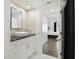 Stylish bathroom with white marble tiles, a white vessel sink on a black countertop, and built-in cabinets at 1501 Gulf Blvd # 201, Clearwater Beach, FL 33767