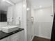 Modern bathroom featuring white subway tiles, black countertop, white vessel sink, and updated fixtures at 1501 Gulf Blvd # 201, Clearwater Beach, FL 33767