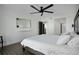 Bright bedroom features wood-look floors, a ceiling fan, and a view of the ensuite bath and closets at 1501 Gulf Blvd # 201, Clearwater Beach, FL 33767