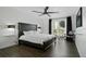 Bright bedroom features a dark wood bed frame, wood floors and sliding doors to a balcony at 1501 Gulf Blvd # 201, Clearwater Beach, FL 33767