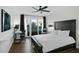 Bright bedroom features a dark wood bed frame, desk, wood floors and sliding doors to a balcony at 1501 Gulf Blvd # 201, Clearwater Beach, FL 33767