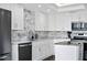 Modern kitchen features white cabinets, stainless steel appliances, granite countertops, and a stylish backsplash at 1501 Gulf Blvd # 201, Clearwater Beach, FL 33767