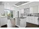 Modern kitchen with white cabinetry, a center island, stainless steel appliances, and a view of the balcony at 1501 Gulf Blvd # 201, Clearwater Beach, FL 33767