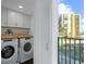 Laundry room with front loading washer/dryer, wood counter and view of oceanfront building at 1501 Gulf Blvd # 201, Clearwater Beach, FL 33767