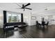 Bright living space featuring a large window with black curtains, hardwood floors, and an open dining area at 1501 Gulf Blvd # 201, Clearwater Beach, FL 33767