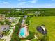 Scenic aerial view of community featuring pool, playground, green spaces, pond, and mature trees at 17342 Lawn Orchid Loop, Land O Lakes, FL 34638