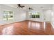 Bright living room with hardwood floors, ample natural light from large windows, and modern ceiling fans at 17342 Lawn Orchid Loop, Land O Lakes, FL 34638