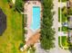 Aerial view of a community pool with chairs, tables, pool house, and manicured landscaping at 17342 Lawn Orchid Loop, Land O Lakes, FL 34638