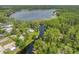 Aerial view of a large lake with canal access surrounded by lush greenery and waterfront homes at 18202 Abbey Ln, Lutz, FL 33548