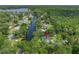 Aerial view of a house surrounded by lush trees and a waterway, showcasing its serene setting at 18202 Abbey Ln, Lutz, FL 33548