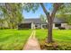 Charming backyard with a stepping stone path to the dock, an enclosed porch and lots of yard space at 18202 Abbey Ln, Lutz, FL 33548