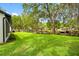 Lush backyard with mature trees, leading to a private dock, perfect for outdoor relaxation and enjoying the waterfront at 18202 Abbey Ln, Lutz, FL 33548