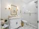 Stylish bathroom with white vanity, gold-framed mirror, and glass-enclosed shower at 18202 Abbey Ln, Lutz, FL 33548