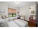 Bright bedroom with twin beds, window view, and doorway to another room at 18202 Abbey Ln, Lutz, FL 33548