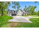 Stunning home featuring a circular driveway, manicured lawn, and a detached garage with a modern design at 18202 Abbey Ln, Lutz, FL 33548