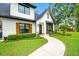 Charming front entrance with a curved walkway, manicured bushes, and decorative shutters accenting the windows at 18202 Abbey Ln, Lutz, FL 33548