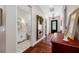 Hallway with hardwood floors, decorative mirror, and a glimpse of a bathroom featuring a vanity and patterned floors at 18202 Abbey Ln, Lutz, FL 33548